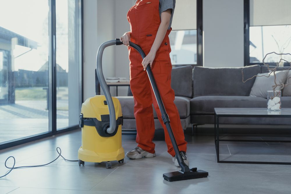Professional cleaner vacuuming a living room